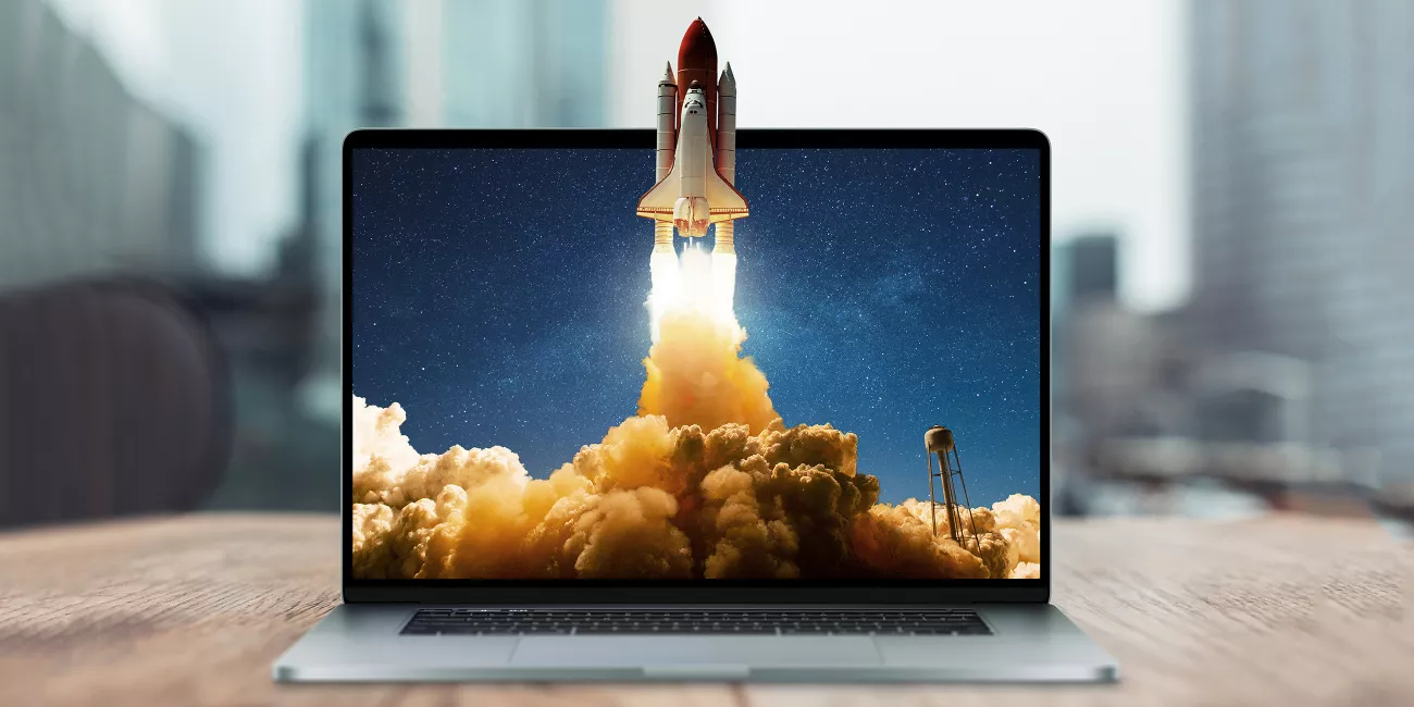 Space rocket shuttle with a cloud of smoke and blast takes off from a laptop on a working office desk