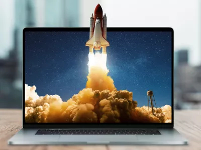 Space rocket shuttle with a cloud of smoke and blast takes off from a laptop on a working office desk